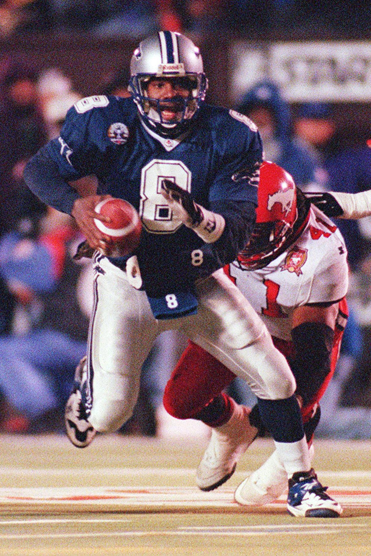 Baltimore Stallions quarterback Tracy Ham flees a Calgary defender during the 1995 Grey Cup.
