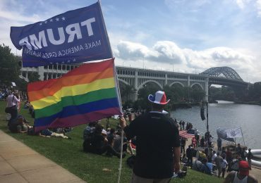Eddy Dee, a member of Democrats for Trump, flies both a Pride and Donald Trump flag at the America First Unity First Rally 2016 outside of the Republican National Convention. (Capital News Service photo by Josh Magness.)