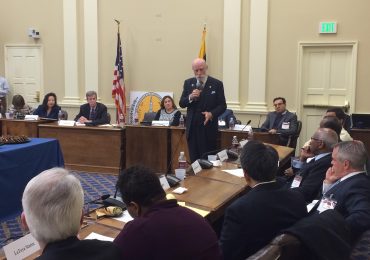 Maryland Attorney General Brian Frosh, left of the American flag, and state Sen. Susan Lee, D-Montgomery, left of Frosh, listen to Vinton Cerf, vice president of Google and keynote speaker at this year’s first meeting of the Maryland Cybersecurity Council on Thursday, February 4, 2016. (Capital News Service photo by Leo Traub)