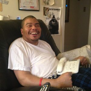 Damon Briggs, 39, cracks a joke in his home in Silver Spring where he lives with his parents. Briggs has moderate to severe cerebral palsy, which affects his ability to walk and grasp small objects, but he explains that it doesn’t impact any of his cognitive abilities or social skills, which is why it frustrates him that transportation issues limit his ability to go out into the community. Capital News Service photo by Grace Toohey.