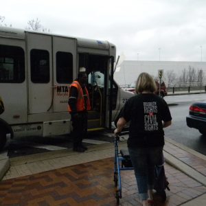 Cheryl Gottlieb uses a walker to assist her as she boards her ride from MTA’s Mobility’s door-to-door service. She said she thinks she has it easier to work Mobility’s system than some customers because she is Internet savvy, which many of the elderly riders are not. Capital News Service photo by Grace Toohey.