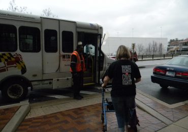 Cheryl Gottlieb uses a walker to assist her as she boards her ride from MTA’s Mobility’s door-to-door service. She said she thinks she has it easier to work Mobility’s system than some customers because she is Internet savvy, which many of the elderly riders are not. Capital News Service photo by Grace Toohey.