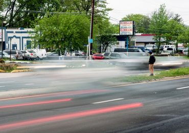 A man looks for a break in traffic to cross University Boulevard in Langley Park. In the past eight years, at least 138 pedestrians have been hit and eight have died on a two-mile stretch of the state highway that runs through the low-income, immigrant community outside Washington, D.C. (Capital News Service photo by Rebecca Rainey)