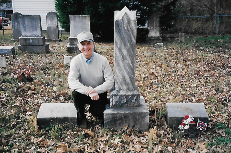 LTC John P. Zebelean III (ret.) posing next to the grave of relative Private Matthew J. Ham, 2nd Regiment, North Carolina Junior Reserves (1861-1865). The plot is located on his family’s former property in Wayne County, NC. Zebelean’s ancestors and five of their slaves are buried here. Photo Courtesy LTC John P. Zebelean III.