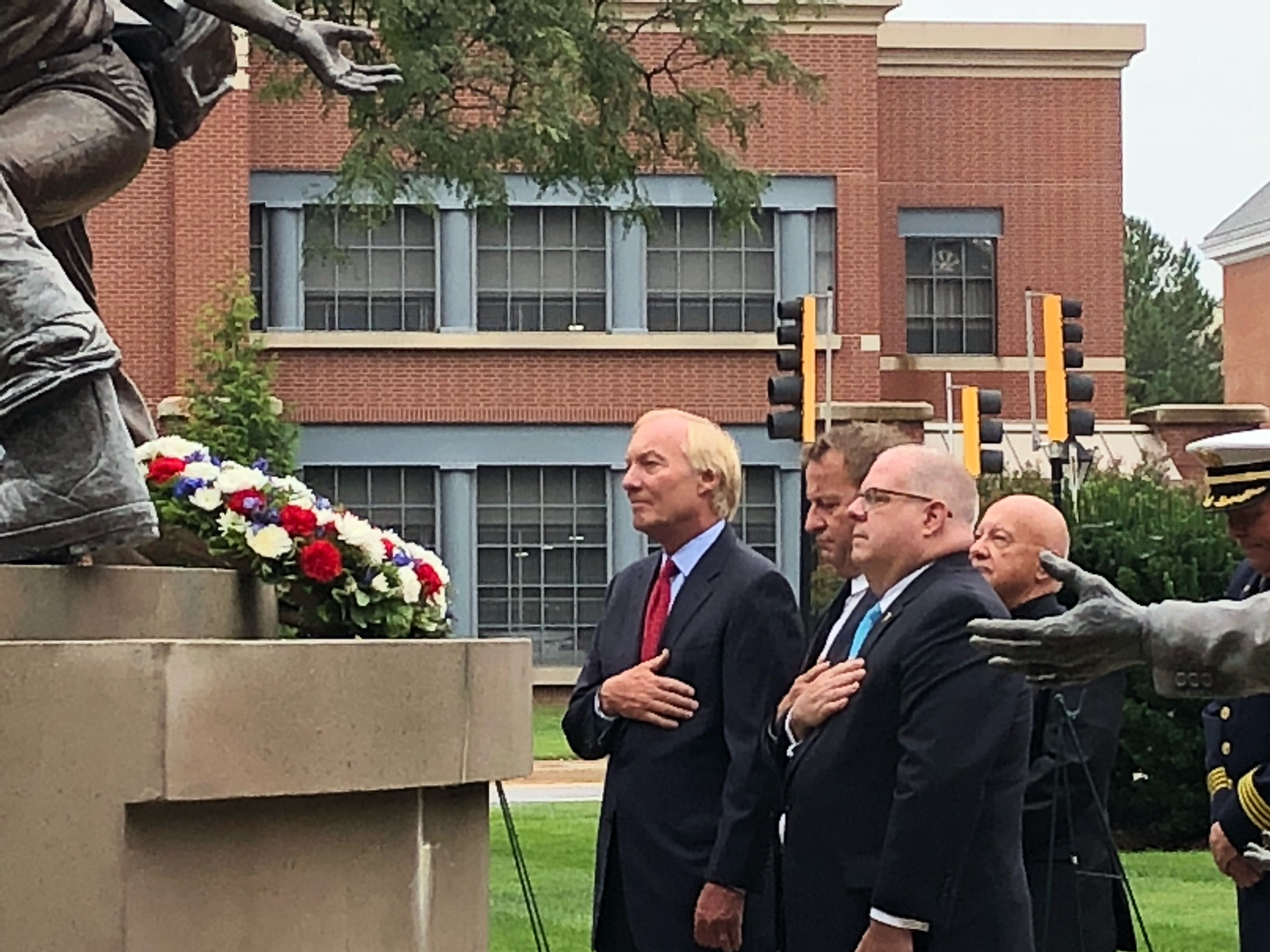 Maryland Gov. Larry Hogan, Annapolis Mayor Gavin Buckley and Maryland Comptroller Peter Franchot stand for a moment of silence before the Maryland Fire-Rescue Services Memorial during a wreath-laying ceremony commemorating the 17th anniversary of the Sept. 11, 2001, terrorist attacks on Sept. 11, 2018, in Annapolis, Maryland. (Photo by Brooks DuBose/Capital News Service)