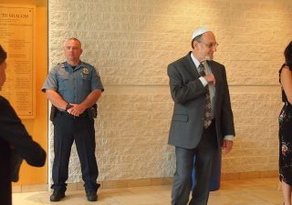 Anne Arundel County Police officer Keith Doyle stands behind attendees arriving for Rosh Hashanah services at Temple Beth Shalom in Arnold, Maryland, on Sept. 30, 2019. Photo by Elliott Davis/Capital News Service.