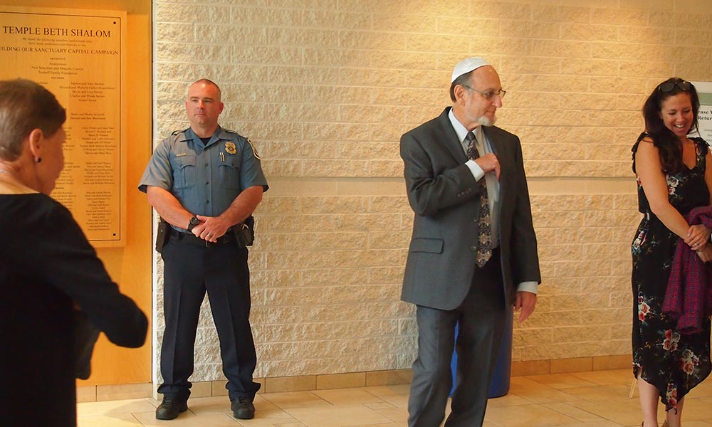 Anne Arundel County Police officer Keith Doyle stands behind attendees arriving for Rosh Hashanah services at Temple Beth Shalom in Arnold, Maryland, on Sept. 30, 2019. Photo by Elliott Davis/Capital News Service.