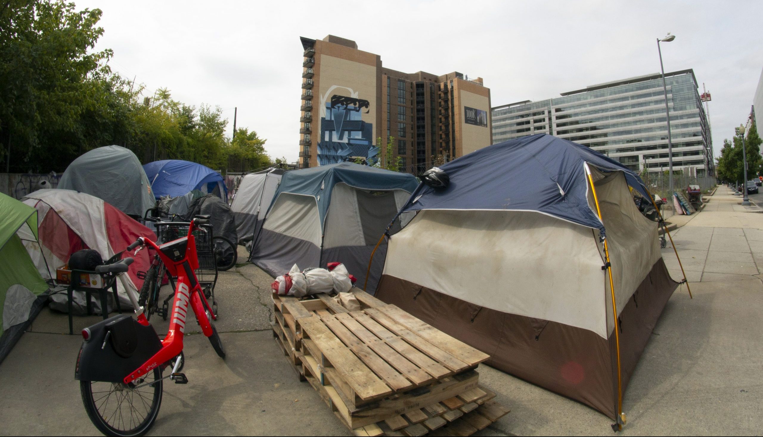 Typically, when encampments are cleared, the residents just set up temporarily nearby. On Sept. 5, 2019, the residents of the L Street NE encampment moved down the block, to the foot of a new luxury apartment building. (Julia Lerner/University of Maryland)