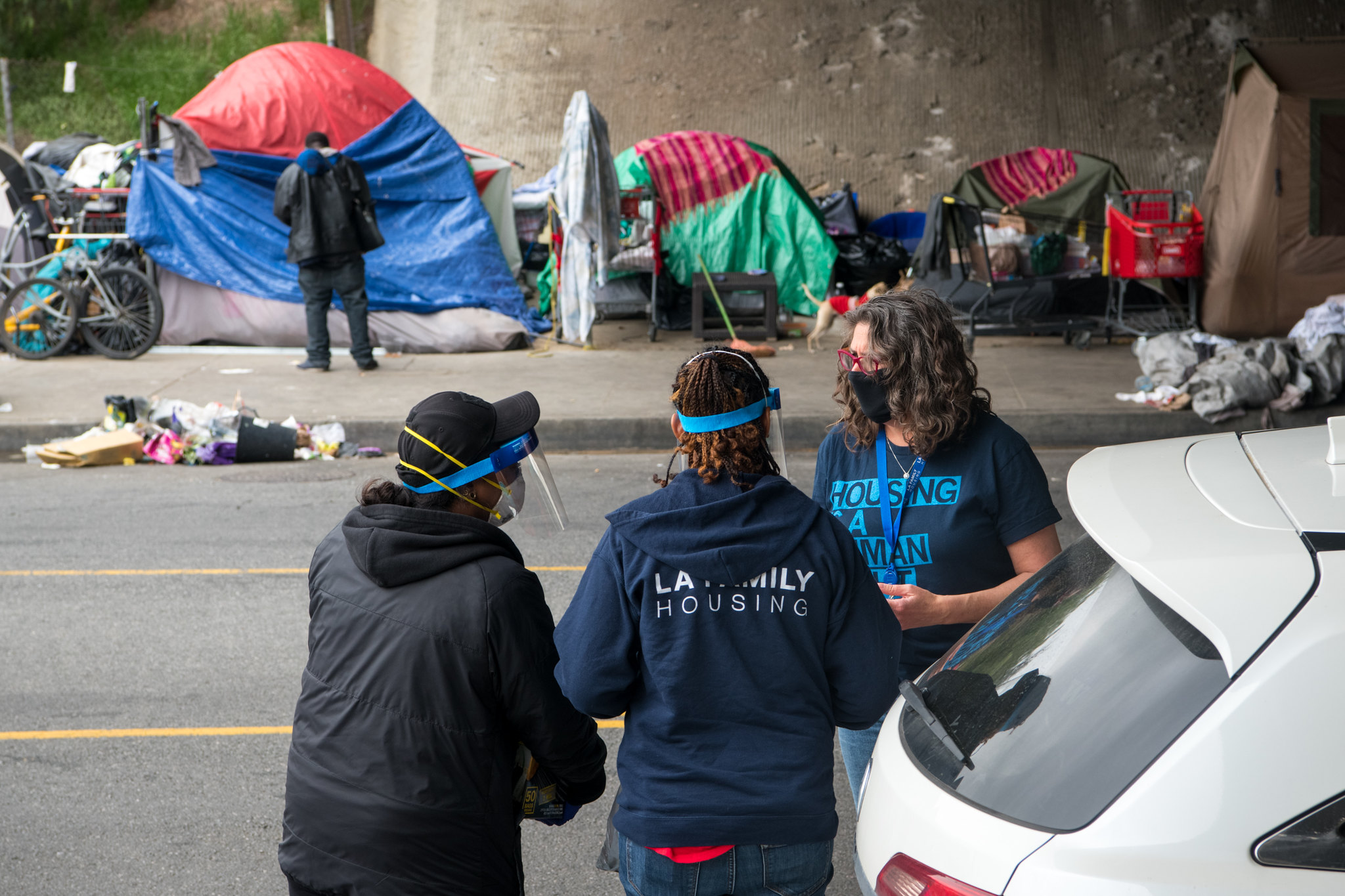 Los Angeles Family Housing President and CEO Stephanie Klasky-Gamer, right, talks with staff as they move homeless people from an encampment into a Project Roomkey hotel, Monday, April 20, 2020. (Photo/Michael Owen Baker)