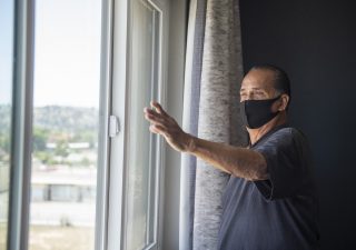 Michael Melcher, a Project Roomkey client, looks out from his fourth-floor hotel room. (Courtesy of Los Angeles County)