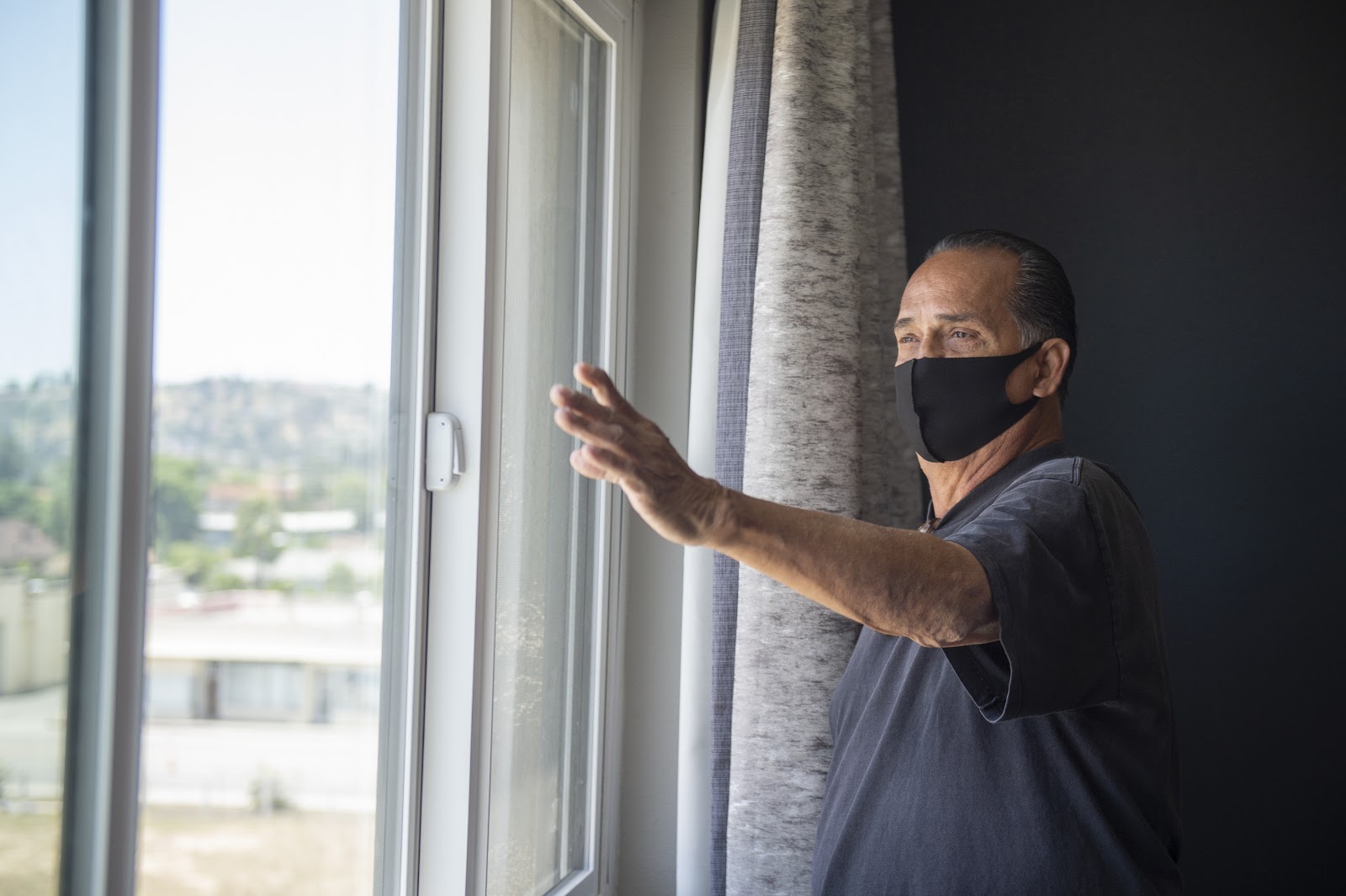 Michael Melcher, a Project Roomkey client, looks out from his fourth-floor hotel room. (Courtesy of Los Angeles County)