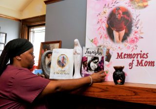 Wyconda Clayton in her home at 2871 N. 45th Street in Milwaukee, Wisconsin, looks over a memorial honoring the sudden passing of three family members just months apart this year. Her mother Eula Clayton died April 14, God-sister Tarnisha Young died May 20, and her oldest sister Sarah Clayton died June 23. (Pat A. Robinson)