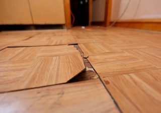 The tile on the kitchen floor is cracked and buckling.