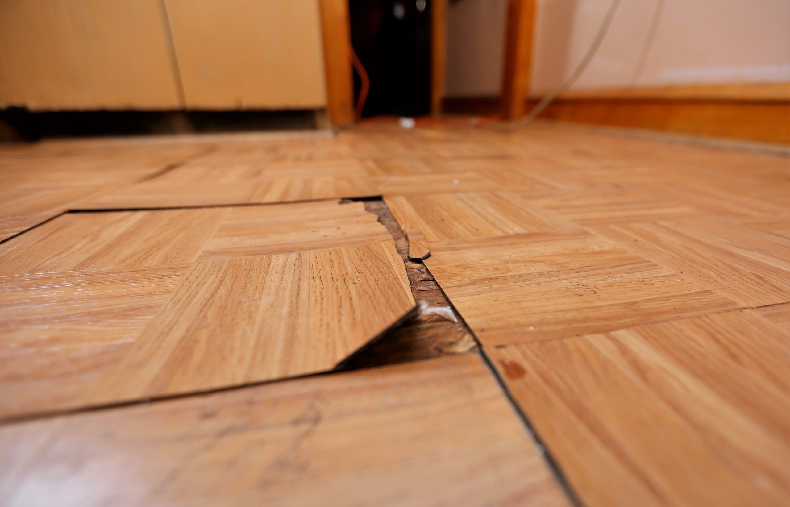 The tile on the kitchen floor is cracked and buckling.