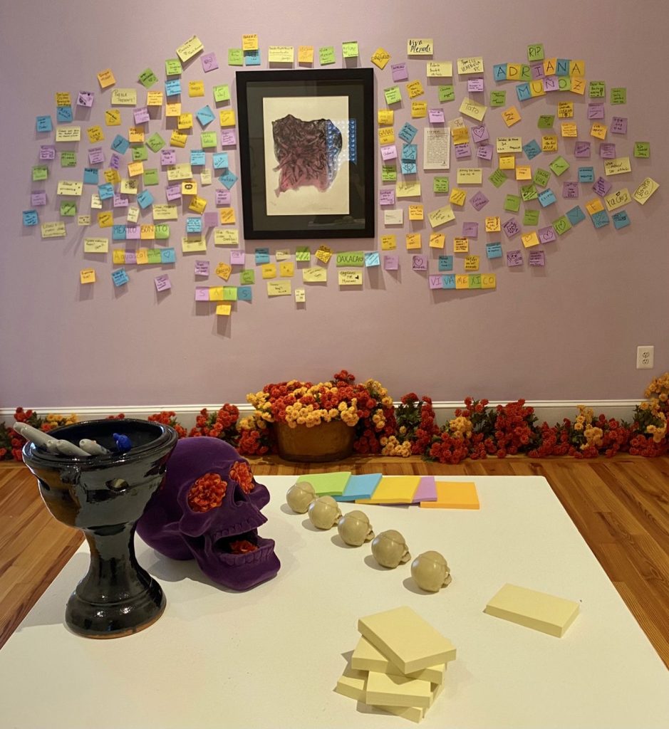 On Oct. 8, 2021, a Day of the Dead exhibit is on display at the Mexican Cultural Institute of the Embassy of Mexico in Washington, D.C. It showcases a decorative skull, traditional marigold flowers and a wall of sticky notes on which some people wrote names of loved ones dead from COVID-19. (Photo: Trisha Ahmed / Capital News Service)