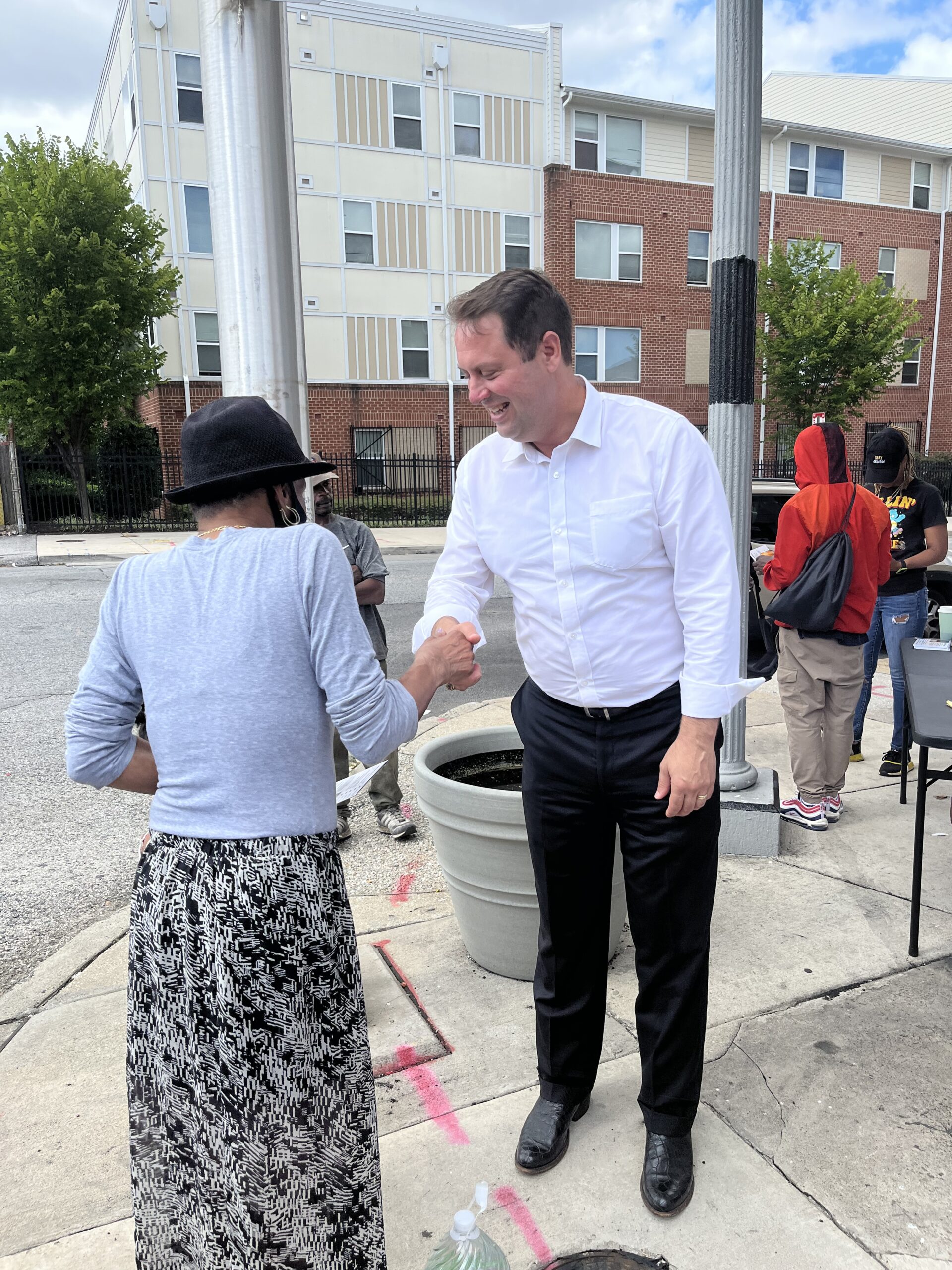 Dan Cox shakes hands with West Baltimore resident