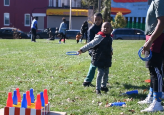 A child plays ring toss at the East Baltimore Graffiti Church's Fall Festival. (Photo by Olivia Wolfson/Capital News Service)