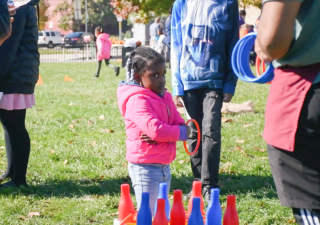 A child playing ring toss at the East Baltimore Graffiti Church's Fall Festival. (Photo: Olivia Wolfson/Capital News Service)