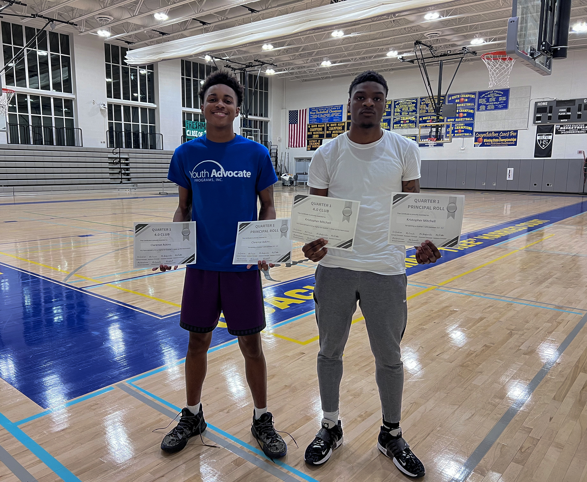 Clarence “Ray” Askins (left), 17, and Kristopher Mitchell (right), 17, show off their 4.0 GPA certificates in the gym of the REACH! Partnership school. Photo by Victoria Vandergriff/Capital News Service