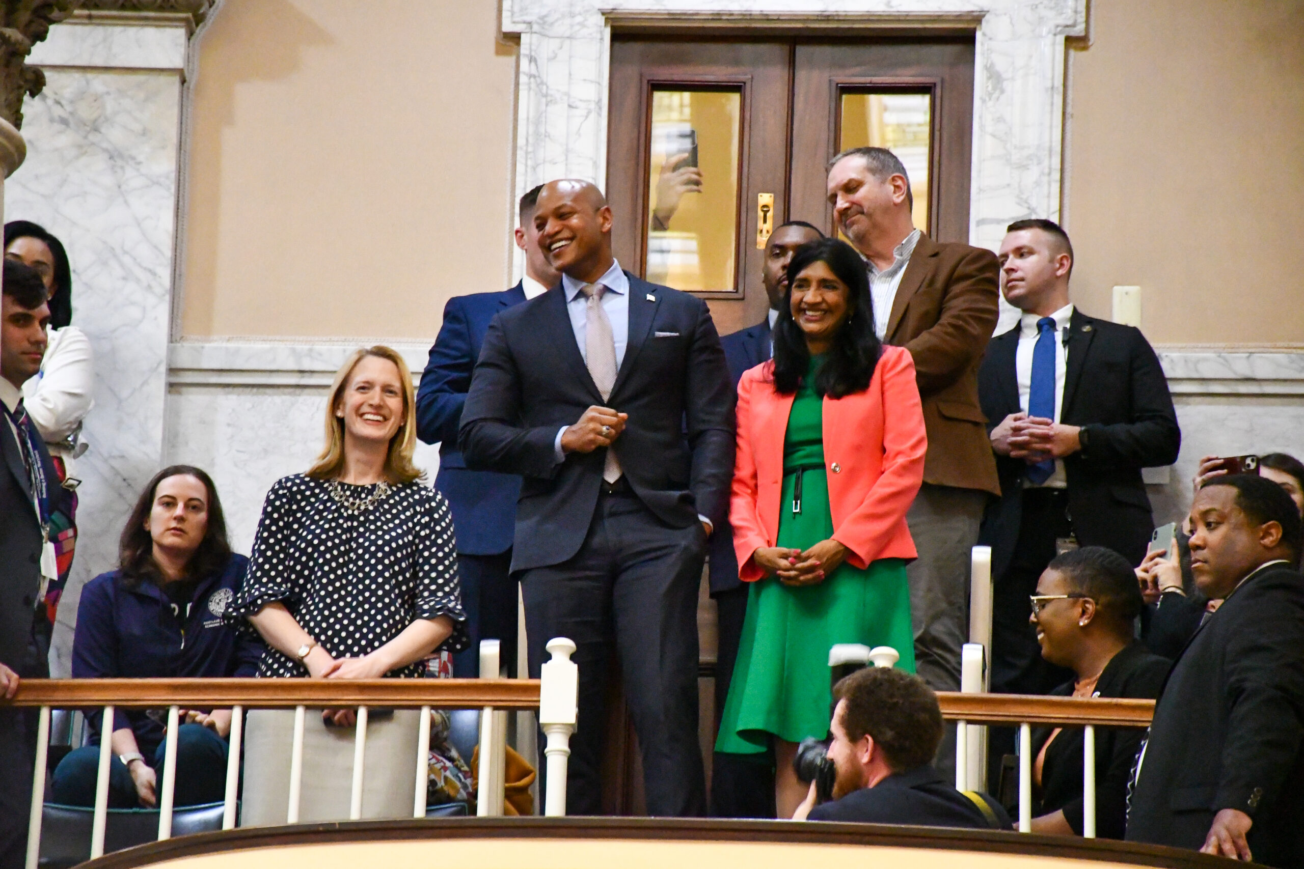 Comptroller Brooke Lierman, Gov. Wes Moore and Lt. Gov. Aruna Miller watch the sine die celebrations from the gallery. (Christine Zhu/Capital News Service)