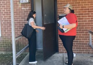 Two legal aid workers knock on a renter's door to distribute fliers.