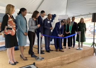 Doctors and lawmakers gather around the ribbon cutting to celebrate the opening of a new mental health center.