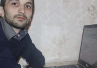 Polad Aslanov sits down to use his computer. (Courtesy of Gulmira Aslanova and Fuad Hasanov)