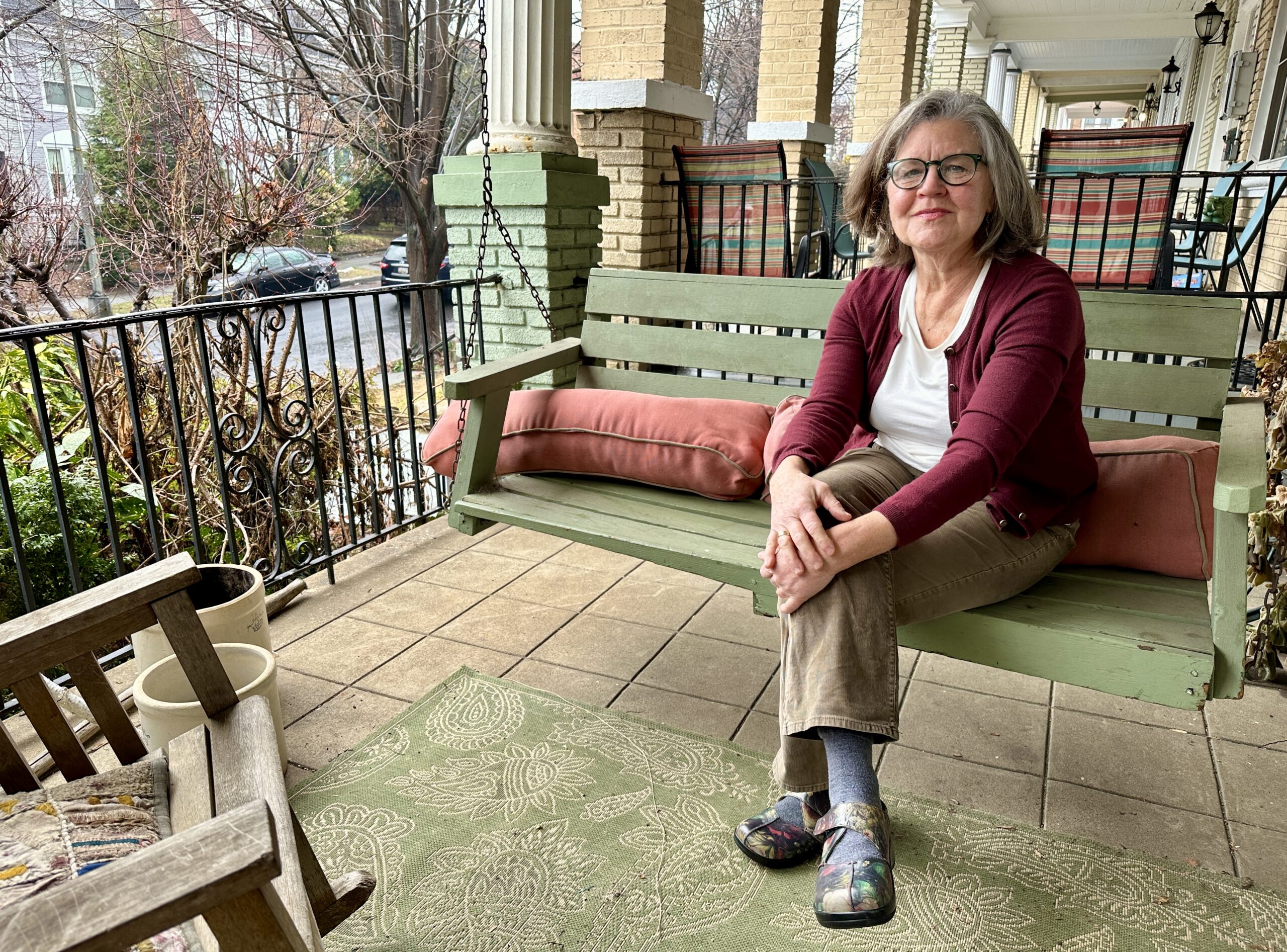 Dixcy Bosley, a nurse care manager who specializes in hospice and end-of-life care, sits on a porch swing outside her Washington, D.C., home on Jan. 25, 2024. (Sapna Bansil/Capital News Service)