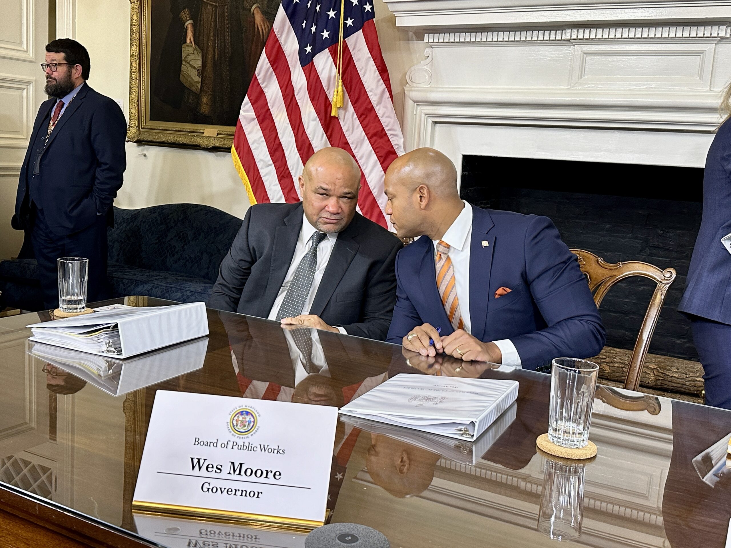 State Treasurer Dereck Davis (left) and Gov. Wes Moore (right) convene after a meeting of the Board of Public Works on Jan. 31, 2024, where each addressed news reports about a sale of the Baltimore Orioles. (Sapna Bansil/Capital News Service)