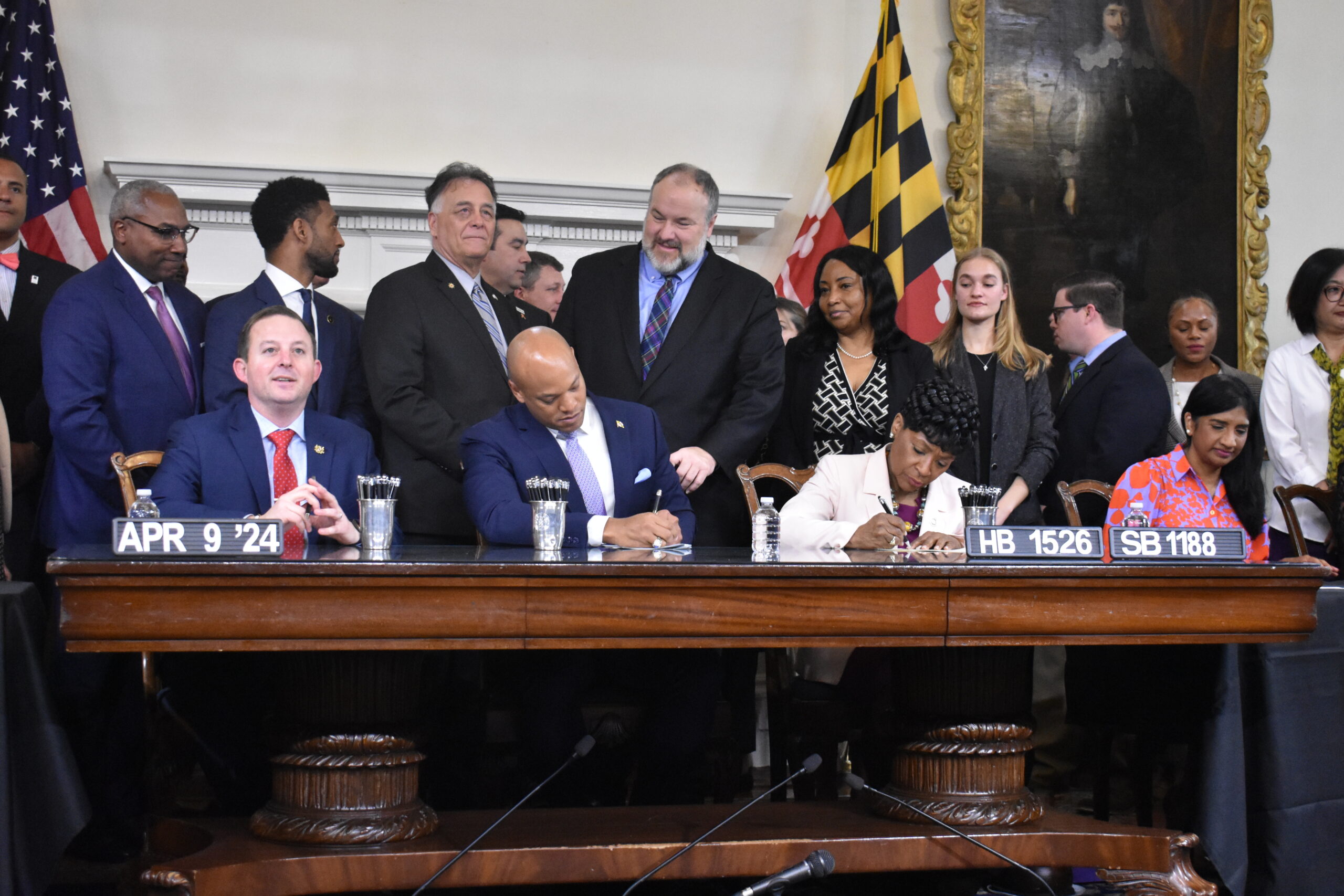 Maryland Gov. Wes Moore (center) signs the PORT Act during a bill signing ceremony on April 9, 2024, hours after the end of the legislative session. The new law includes a provision creating a scholarship for family members of fallen construction and transportation workers. (Kiersten Hacker/Capital News Service)