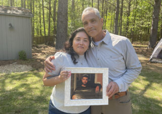 Patricia Ragan and her father, Rodrigo Arreola, hold a photo of her brother, Hector Arreola, outside of Rodrigo Arreola's home on April 11, 2023, in Columbus, Ga. The cause of Hector Arreola's death was changed from an accident to homicide caused by "sudden cardiac death following struggle with law enforcement including prone position restraint complicating acute methamphetamine toxicity.'' In 2021, his family was awarded $500,000 in damages in a settlement with the city of Columbus. (Eve Sampson/Howard Center for Investigative Journalism via AP)