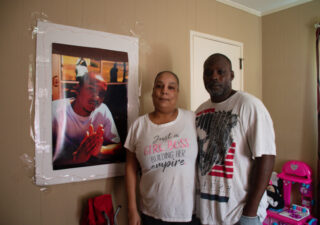 Keyana Gaines and her husband, Kenyatta Crawford, stand near a photo of Gaines’ son, Jermaine Jones, at their home in Augusta, Georgia, on April 16, 2023. (Photo by Paige Maizes/Howard Center for Investigative Journalism)