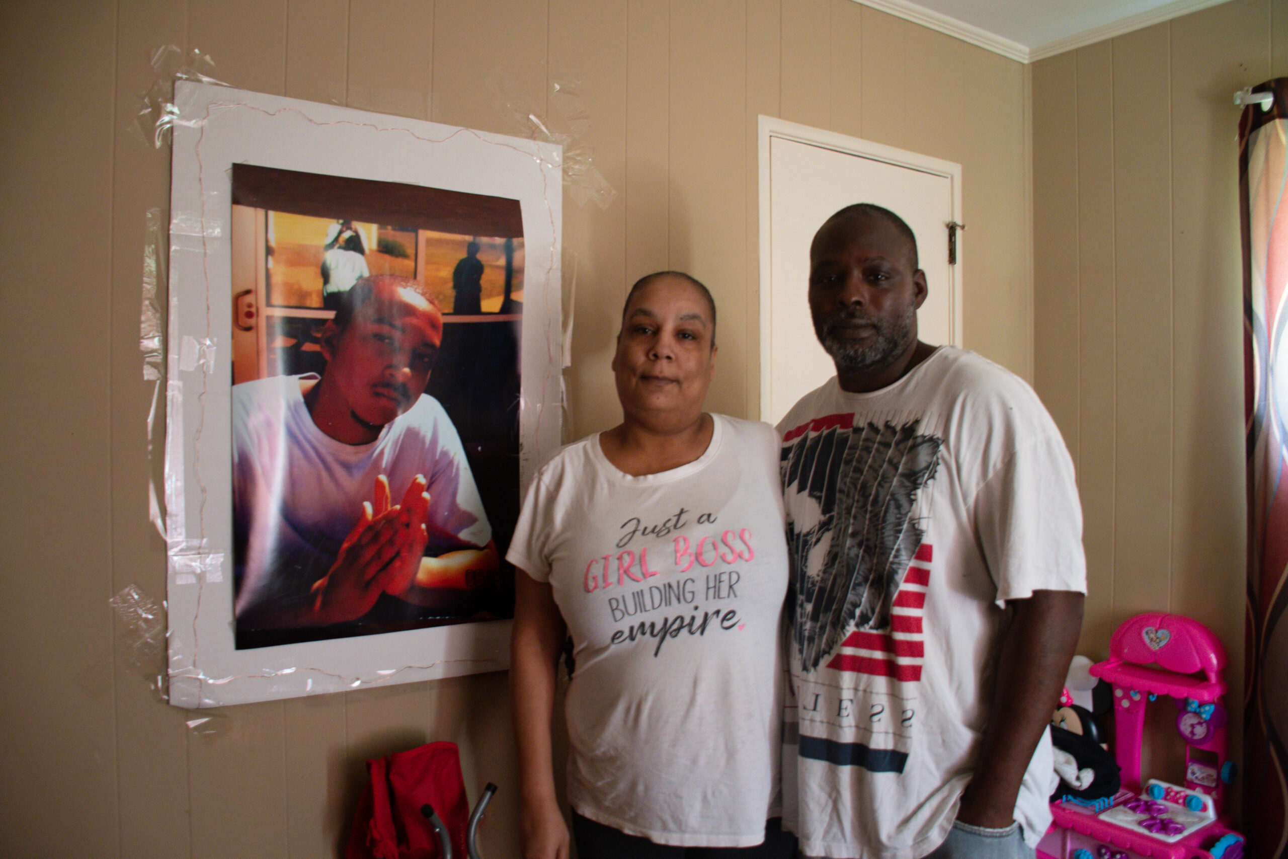 Keyana Gaines and her husband, Kenyatta Crawford, stand near a photo of Gaines’ son, Jermaine Jones, at their home in Augusta, Georgia, on April 16, 2023. (Photo by Paige Maizes/Howard Center for Investigative Journalism)