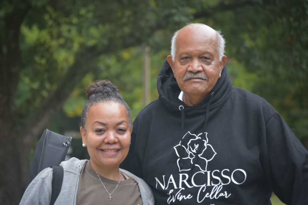 Woman and her father pose for a picture. 