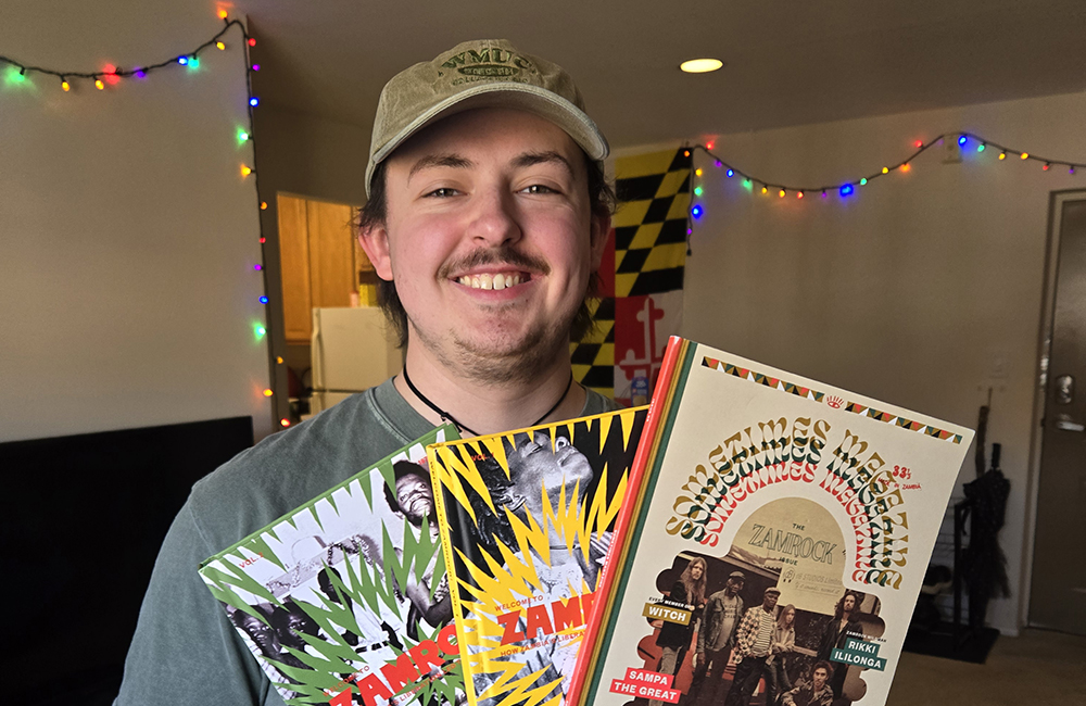 University of Maryland student Jake McInturff in his apartment holding books about Zamrock