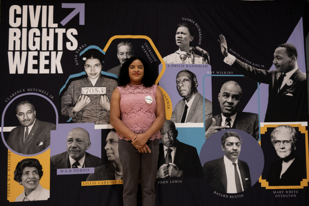 Crisaly De Los Santos was a panelist at an event called “Immigration and Inclusion: A History of Struggle and Progress” hosted by the Baltimore City Office of Equity and Civil Rights at the Thurgood Marshall Center in Baltimore. She stands in front of a poster with the words "Civil Rights Week" with the pictures of several Civil Rights icons such as Rosa Parks, Thurgood Marshall, Gloria Richardson and Martin Luther King Jr. on it. (Andrea Durán/Capital News Service)