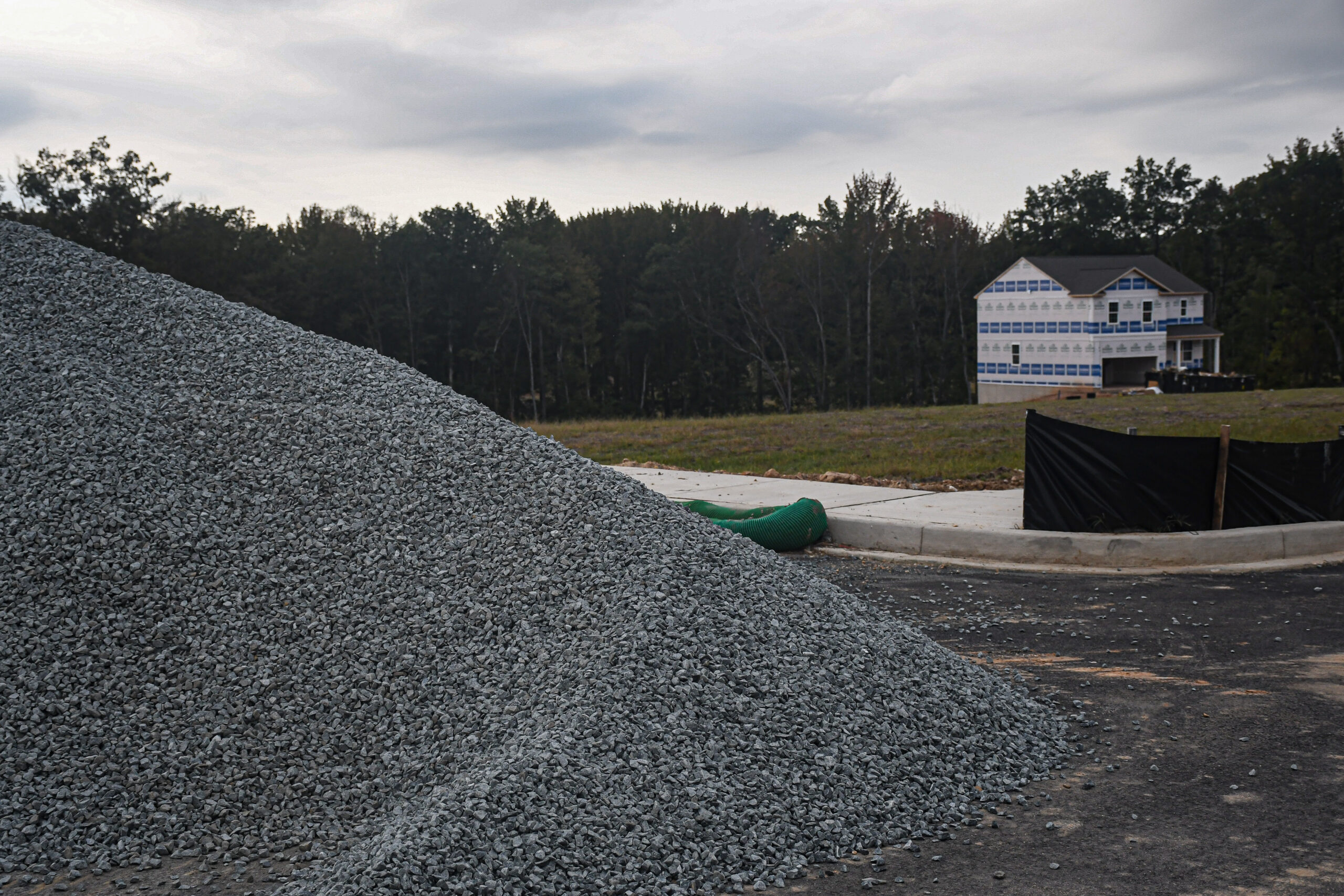 A pile of stones on a construction site in Ridgely’s Reserve, Joppa, Maryland with a newly built house in the backdrop.