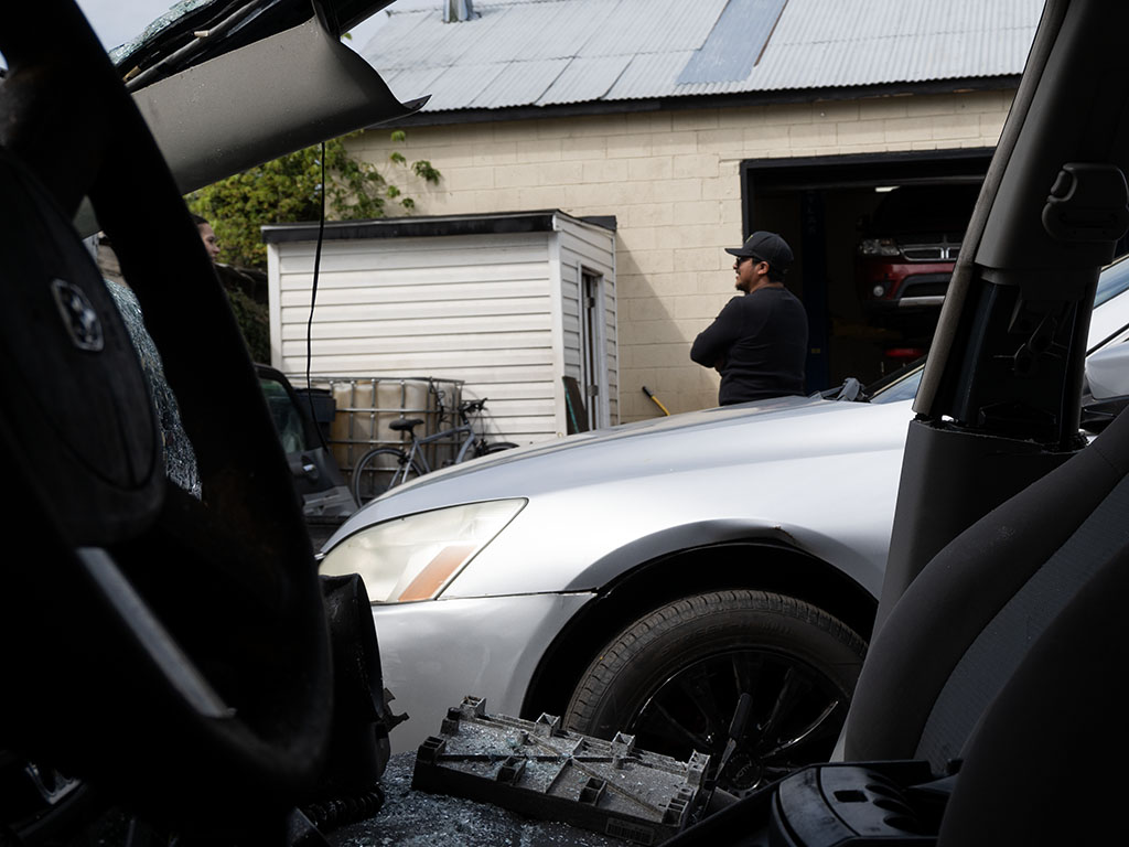 Melvin in front of cars at an auto repair shop in Hyattsville, Maryland.