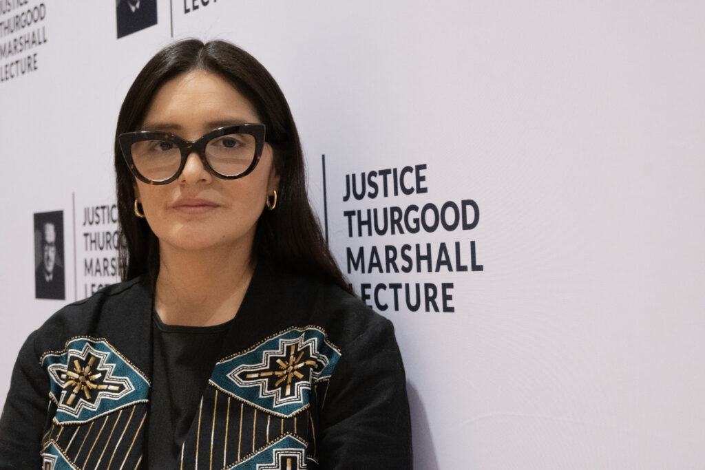 Nilsa Yurivilca-Zuasnabar, at the Thurgood Marshall Center in Baltimore, in front of a backdrop that says "Justice Thurgood Marshall Lecture" multiple times. (Andrea Durán/Capital News Service)