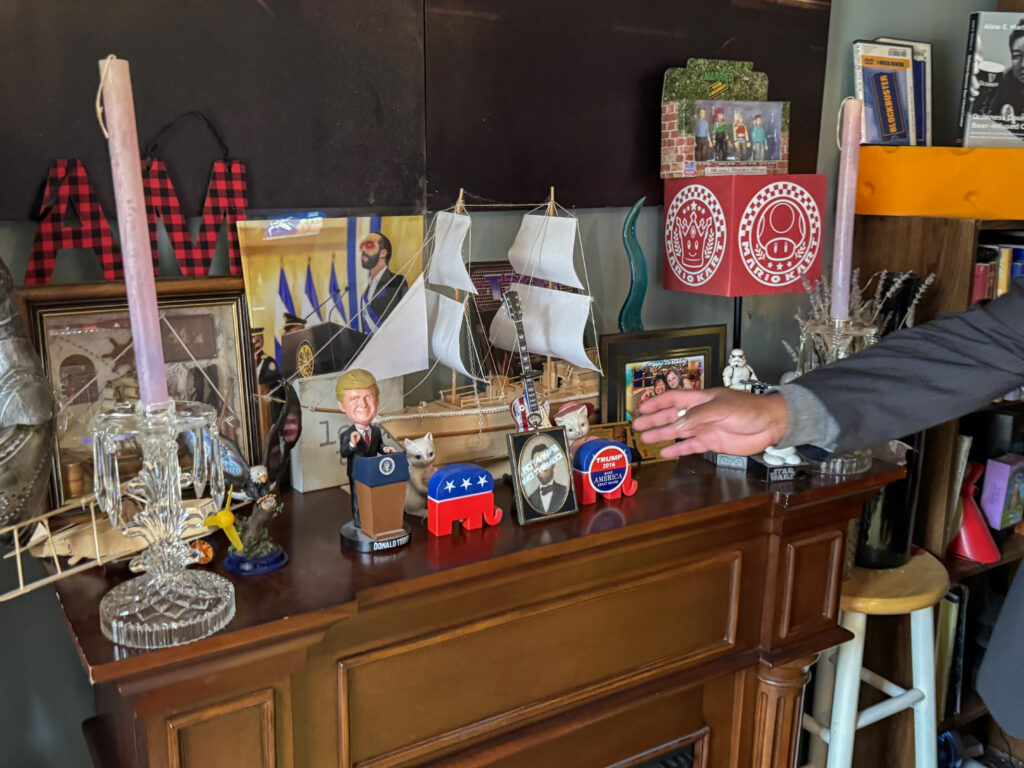 A fireplace mantle covered with knickknacks, including political figures.