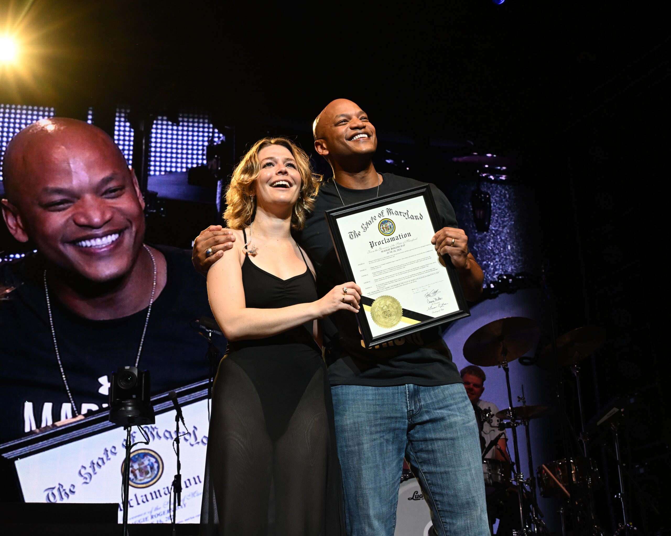 Gov. Wes Moore presents singer-songwriter Maggie Rogers a Maryland State proclamation to make June 16 Maggie Rogers Day at her June 16 concert at Merriweather Post Pavilion.