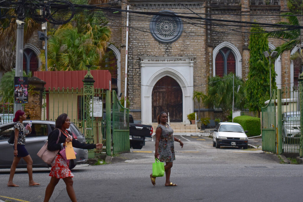 Three women stroll past a church