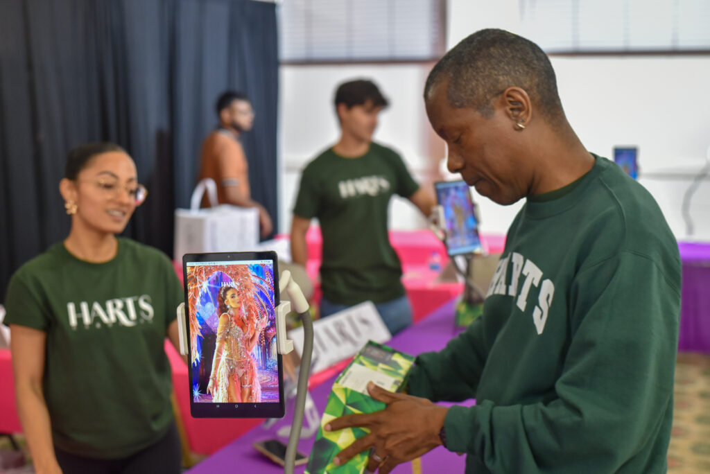 Man in focus next to a display showing a Carnival costume