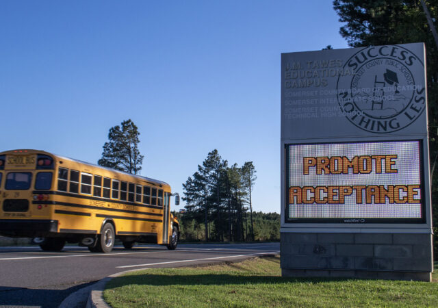 A school bus passes by a sign for Somerset's J.M. Tawes Educational Campus, which includes the Somerset County Board of Education and two public schools.